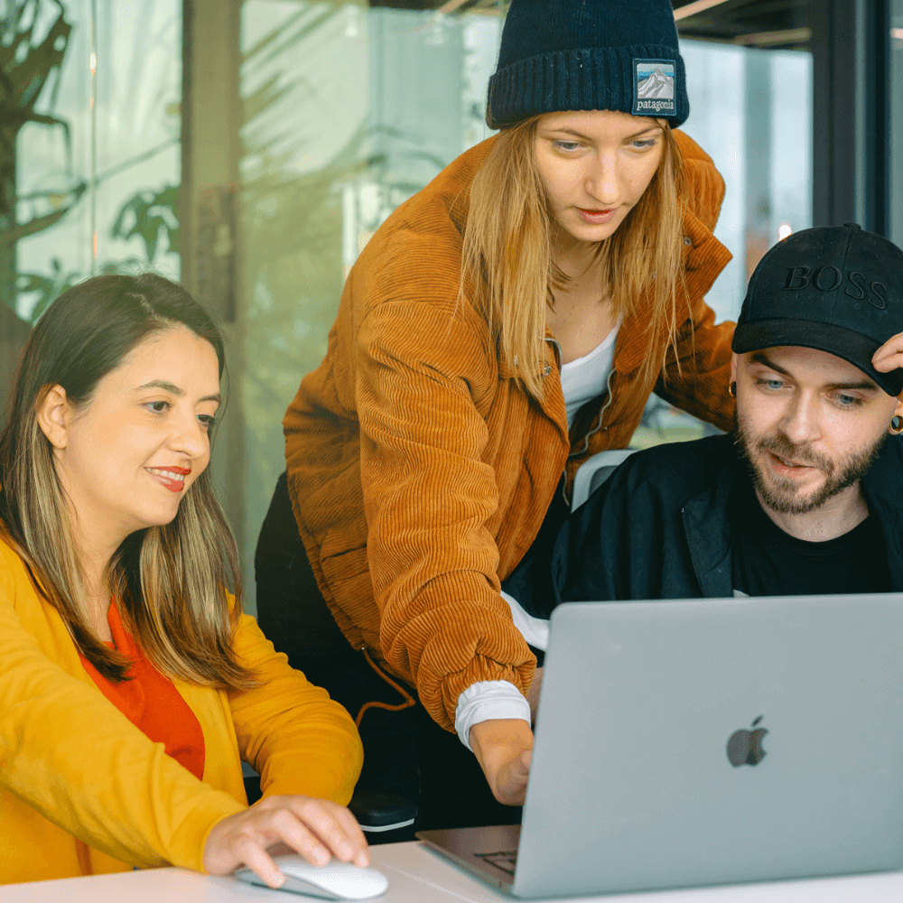 Equipe de e-commerce com duas mulheres e uym homem organiza banco de dados de clientes