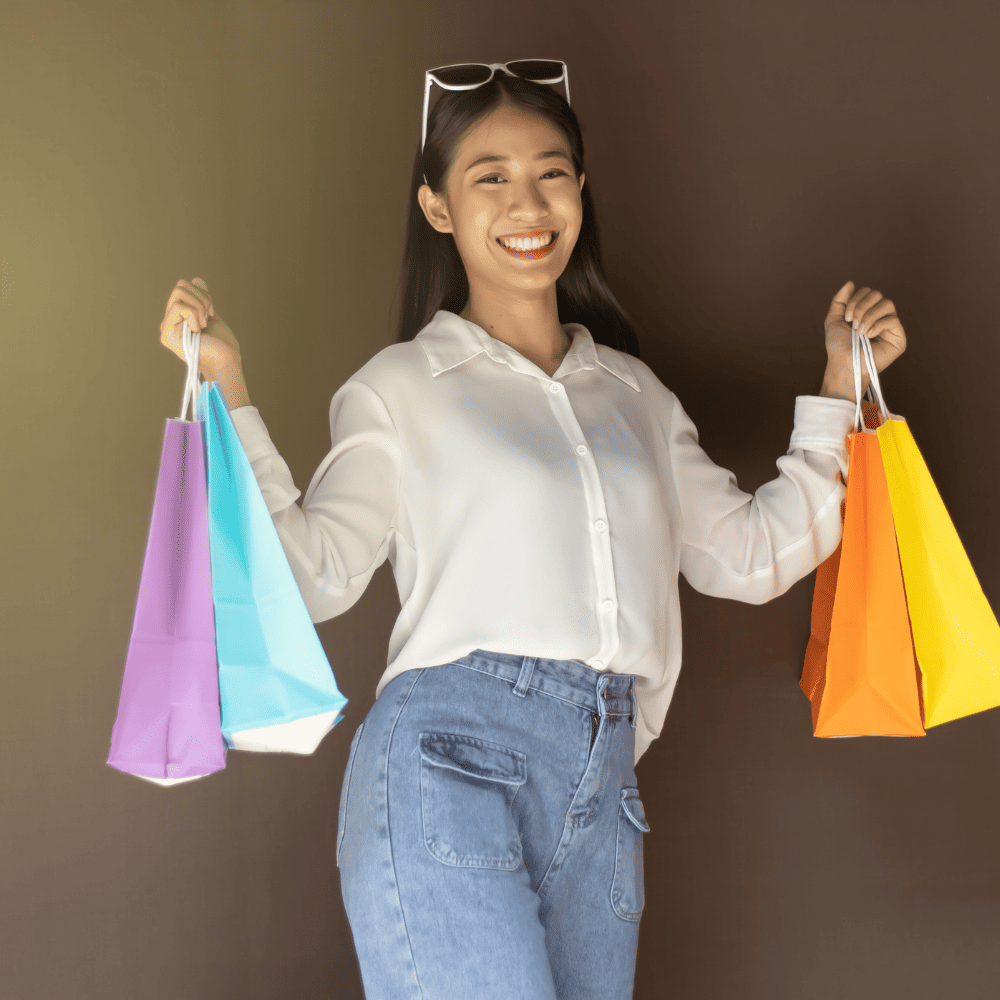 Mulher asiática com sacolas coloridas depois de compras no Dia do Cliente