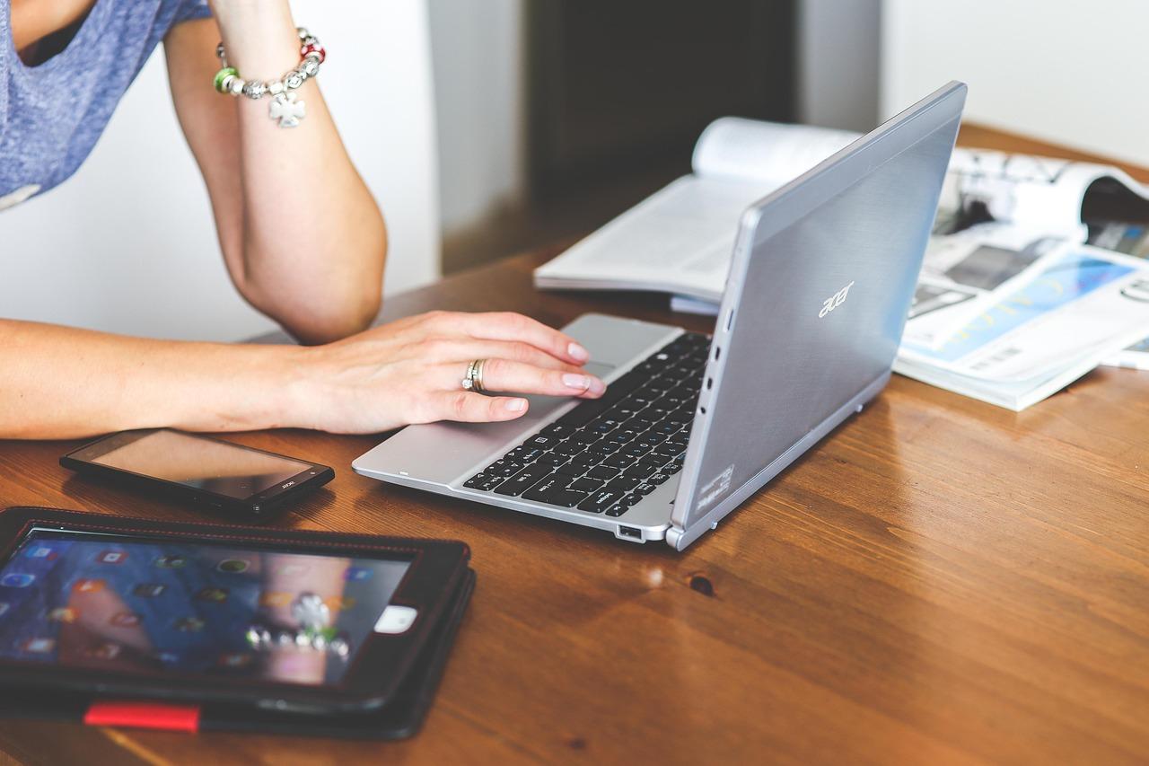 Mulher usa, celular, computador e tablet esperando comunicação multicanal